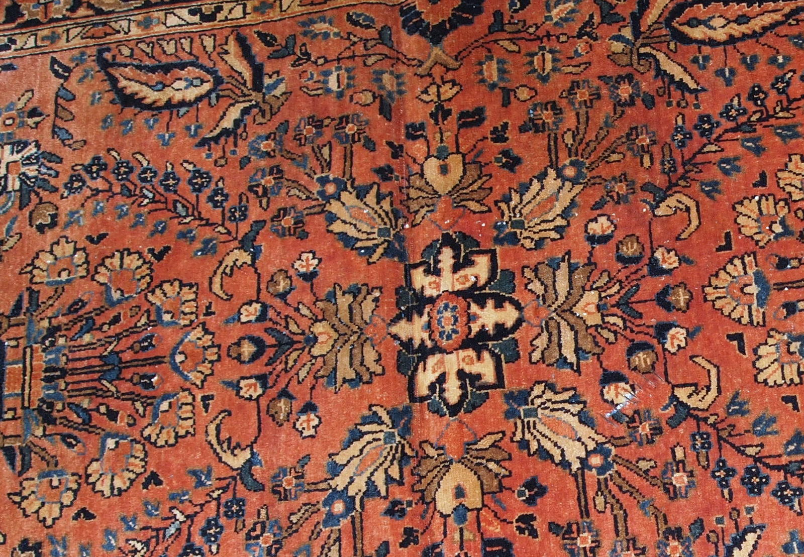 Handmade antique Persian Sarouk rug in original good condition, it has some signs of age. The rug is from the beginning of 20th century made in red wool. 