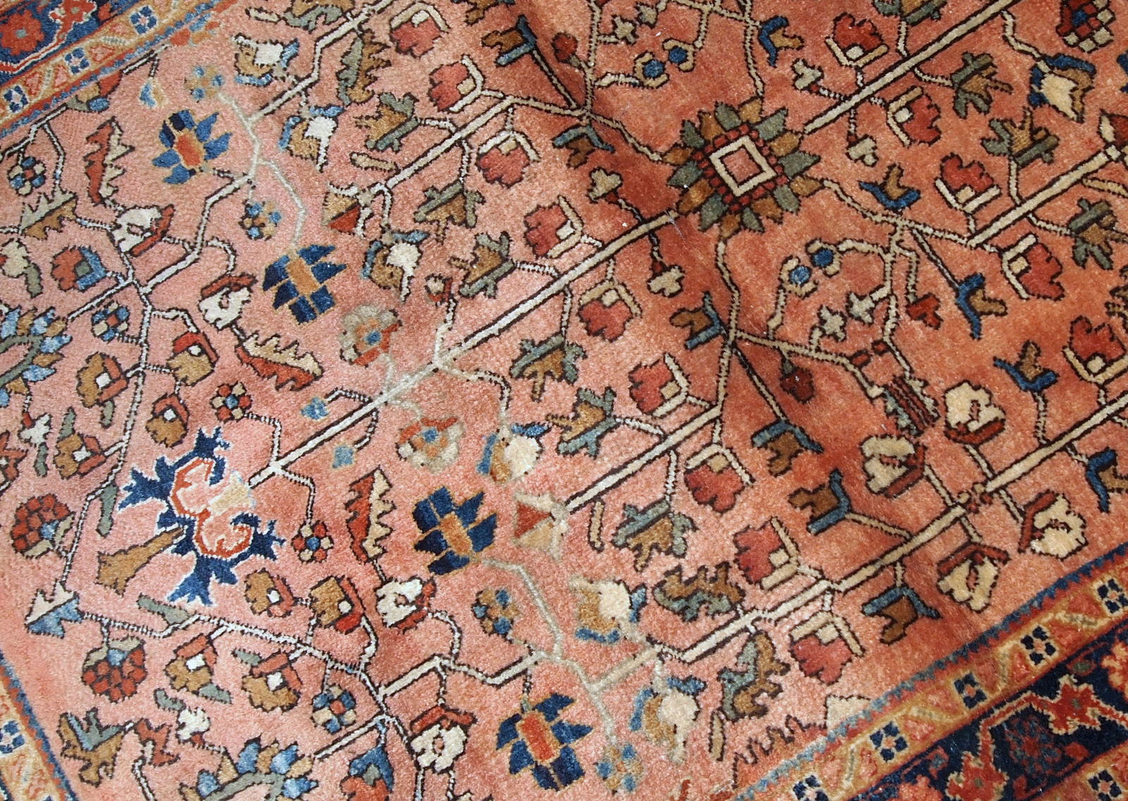 Handmade antique Persian Sarouk rug in original good condition. The rug is from the beginning of 20th century made in pale red wool and unusual design.
