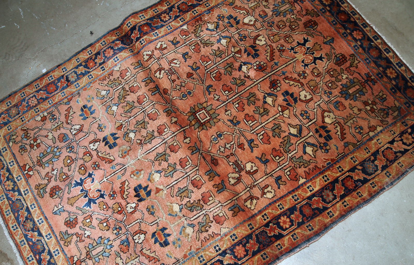 Handmade antique Persian Sarouk rug in original good condition. The rug is from the beginning of 20th century made in pale red wool and unusual design.
