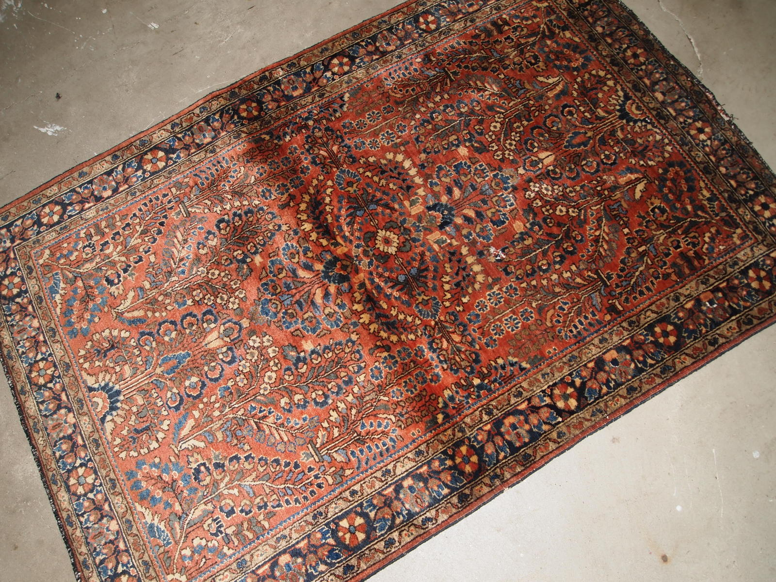 Handmade antique Persian Sarouk rug in original good condition. The rug is from the beginning of 20th century made in red wool.