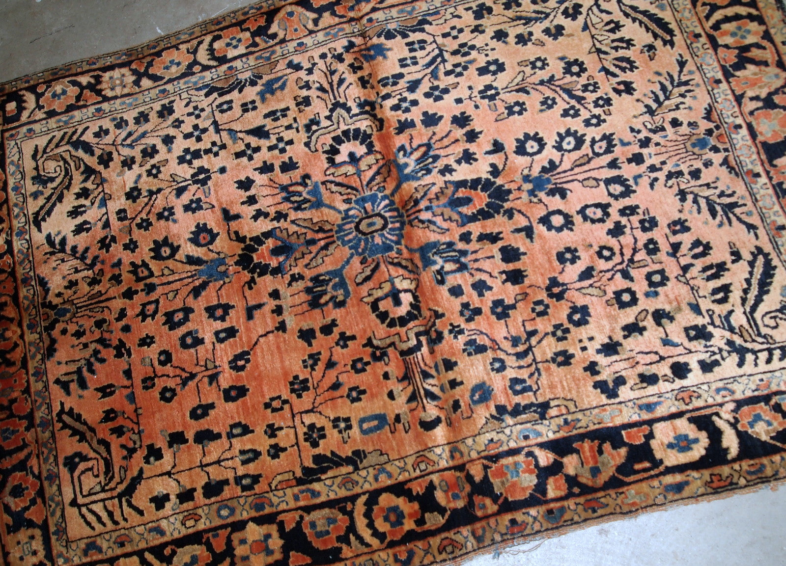 Handmade antique Persian Sarouk rug in original good condition. The rug is from the beginning of 20th century made in pale red wool.