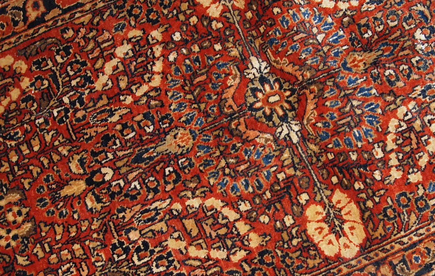 Handmade antique Persian Sarouk rug in original good condition. The rug is from the beginning of 20th century made in red wool.