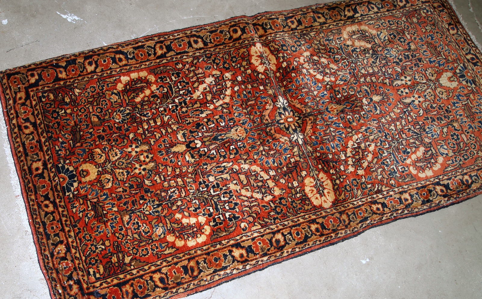 Handmade antique Persian Sarouk rug in original good condition. The rug is from the beginning of 20th century made in red wool.