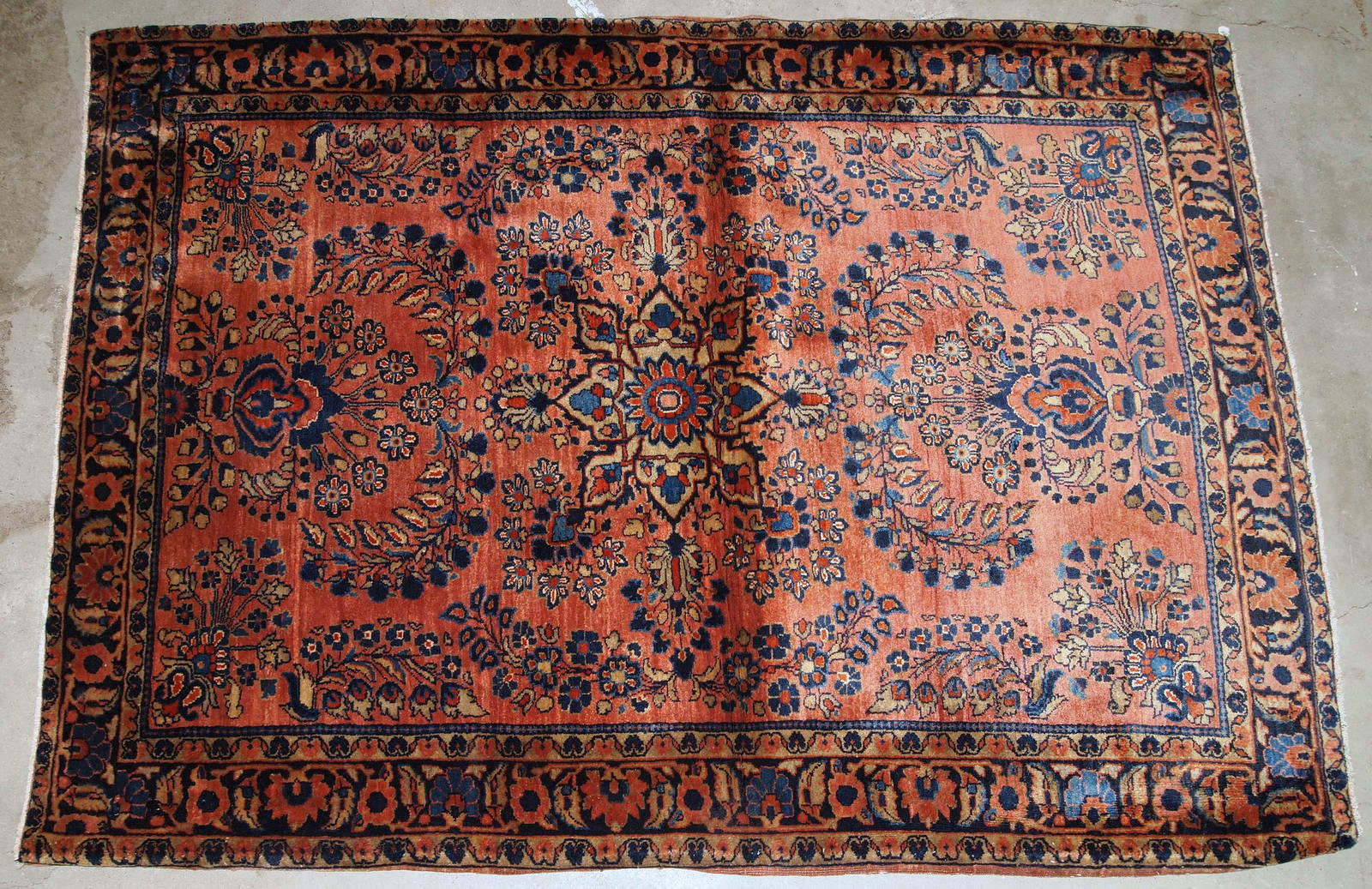 Handmade antique Persian Sarouk rug in original good condition. The rug is from the beginning of 20th century made in red wool.