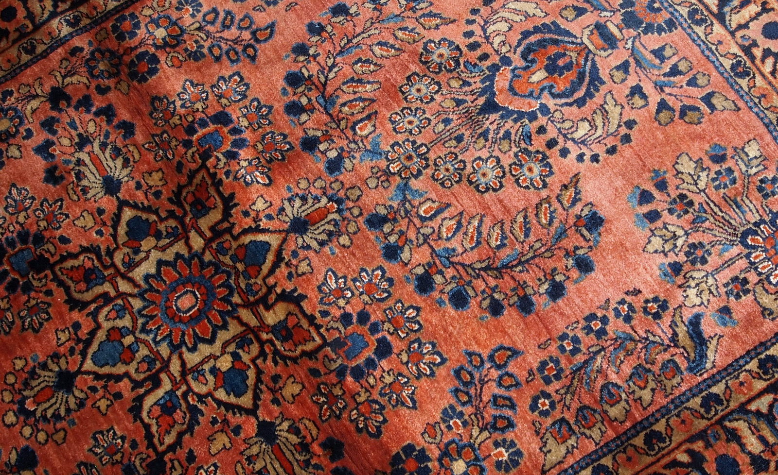Handmade antique Persian Sarouk rug in original good condition. The rug is from the beginning of 20th century made in red wool.