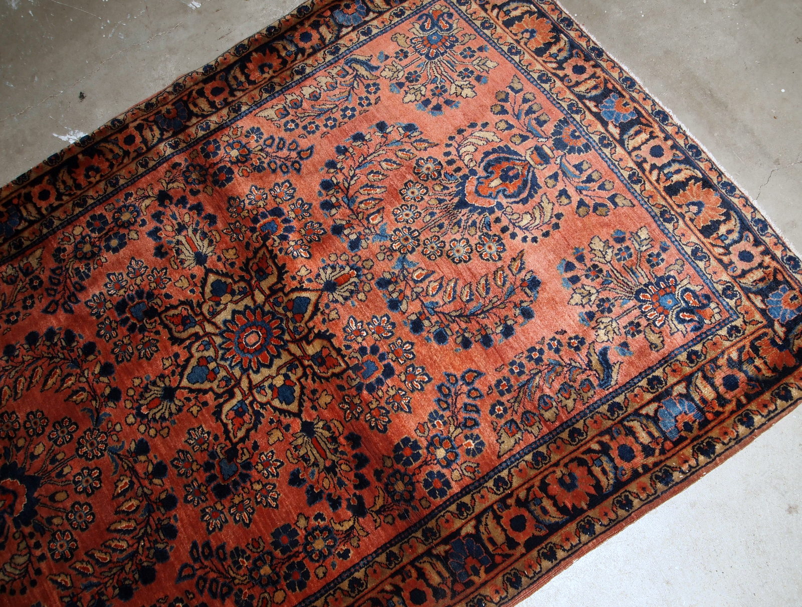 Handmade antique Persian Sarouk rug in original good condition. The rug is from the beginning of 20th century made in red wool.