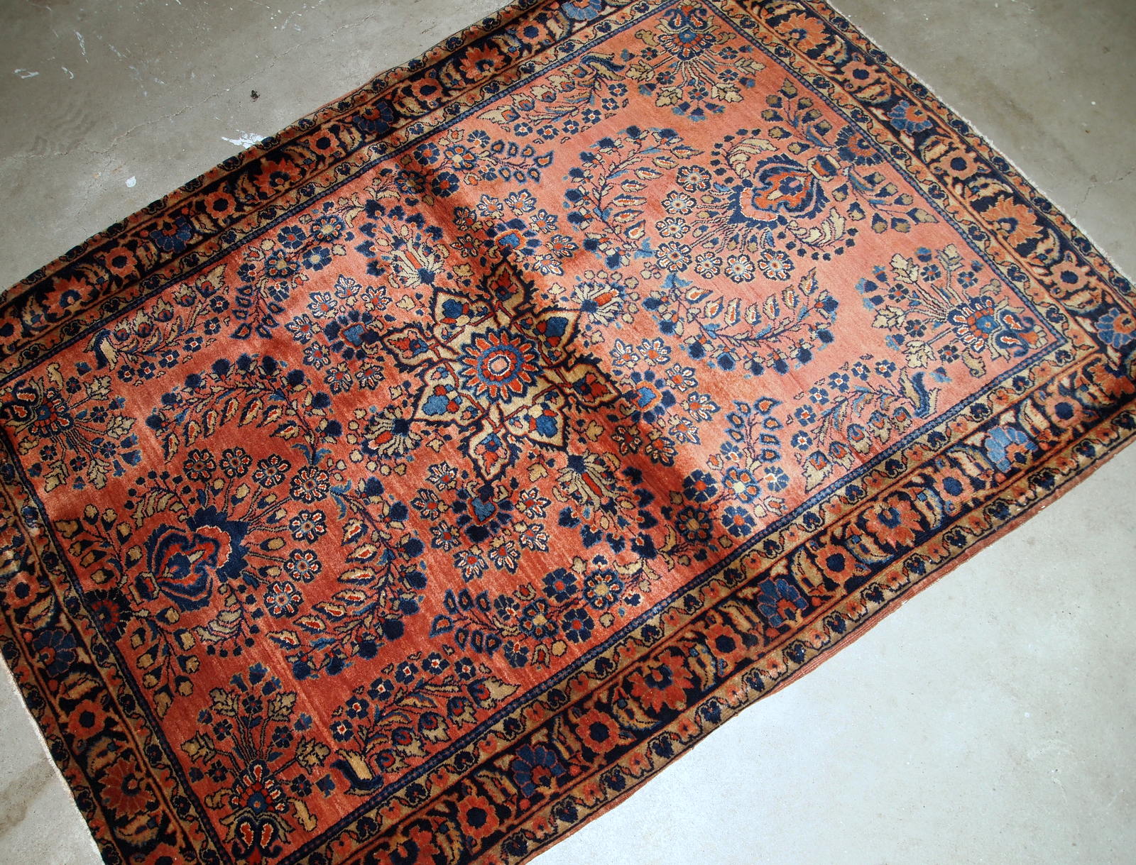 Handmade antique Persian Sarouk rug in original good condition. The rug is from the beginning of 20th century made in red wool.