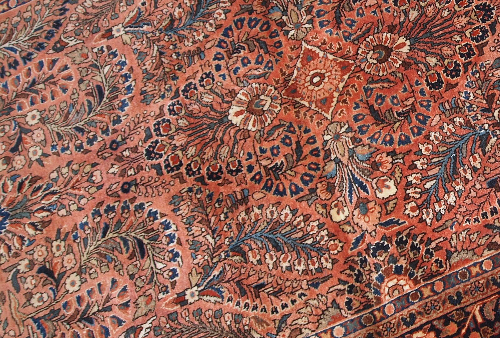 Handmade antique Persian Sarouk rug in original good condition. The rug is from the beginning of 20th century made in red wool.