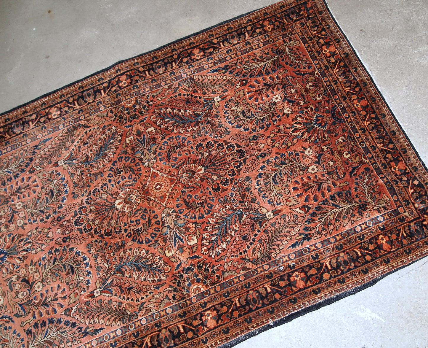 Handmade antique Persian Sarouk rug in original good condition. The rug is from the beginning of 20th century made in red wool.