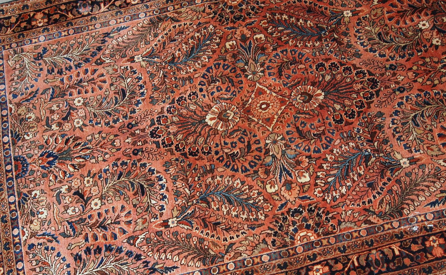 Handmade antique Persian Sarouk rug in original good condition. The rug is from the beginning of 20th century made in red wool.