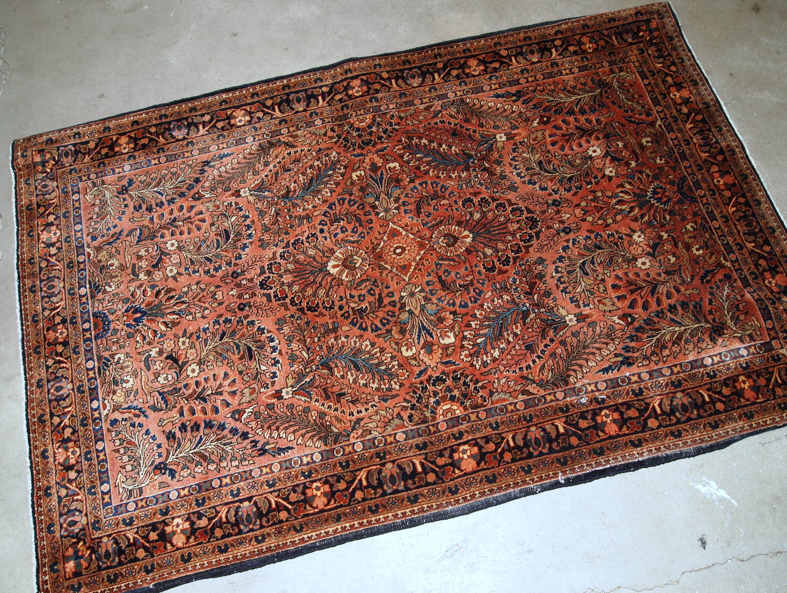 Handmade antique Persian Sarouk rug in original good condition. The rug is from the beginning of 20th century made in red wool.
