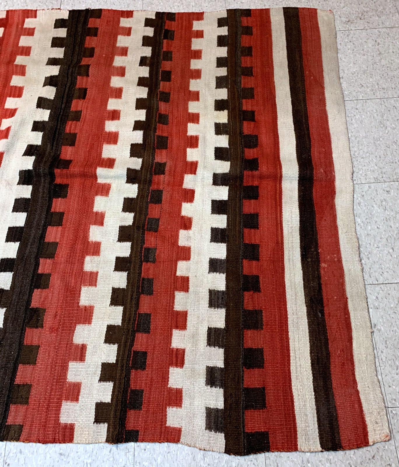 Antique hand-woven American-Indian Navajo blanket in original good condition. The blanket has been made in the end of 19th century in bright red, chocolate brown and white shades.