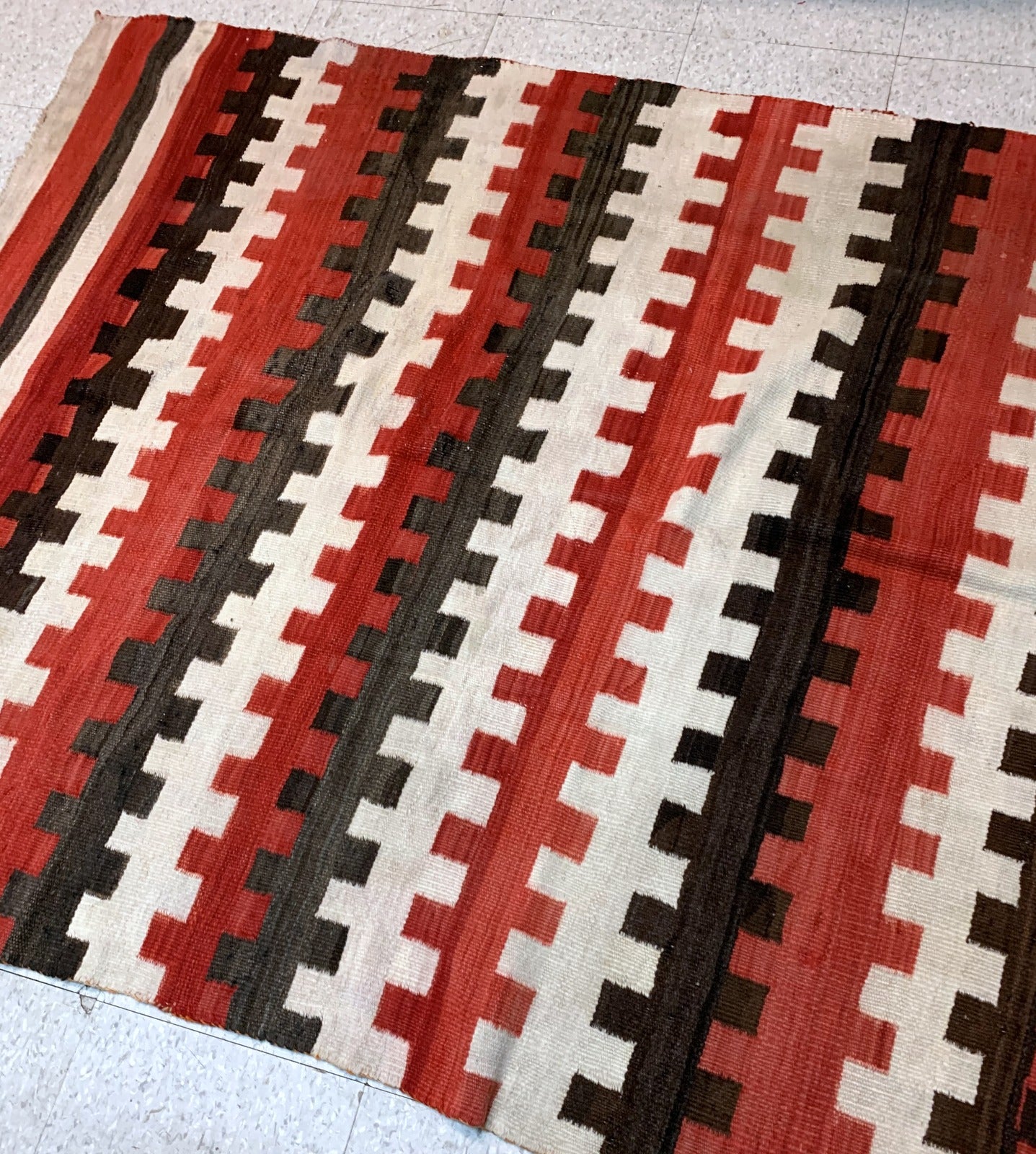 Antique hand-woven American-Indian Navajo blanket in original good condition. The blanket has been made in the end of 19th century in bright red, chocolate brown and white shades.