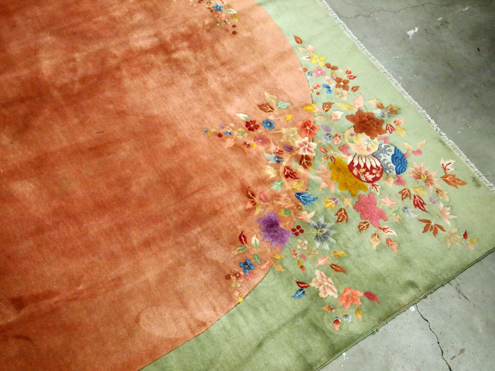 Handmade antique Art Deco Chinese rug in orange and green colors. The rug is from the end of 20th century in original good condition. The rug has a symbol of Indian swastikas'.