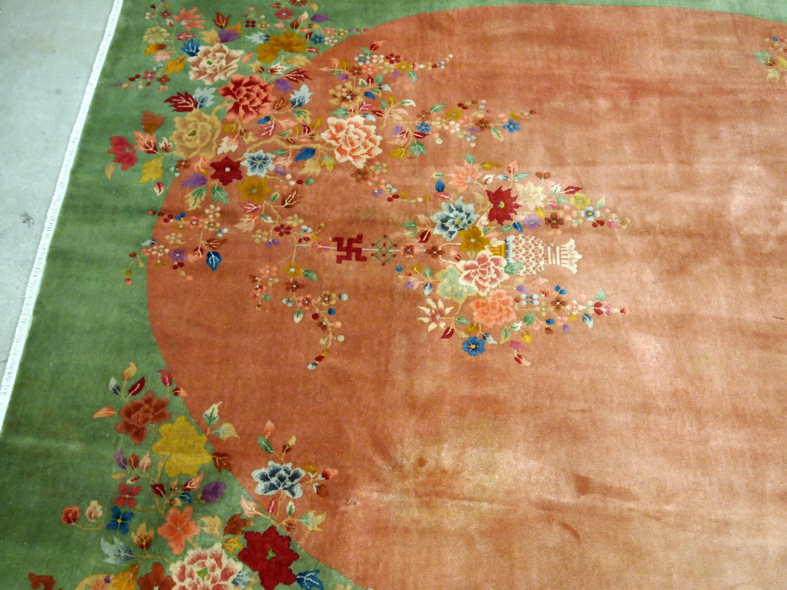 Handmade antique Art Deco Chinese rug in orange and green colors. The rug is from the end of 20th century in original good condition. The rug has a symbol of Indian swastikas'.
