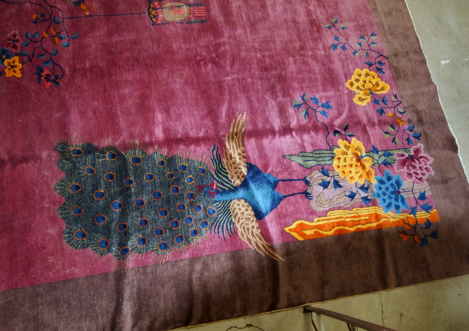 Handmade antique Art Deco Chinese rug in ruby and burgundy shades. The rug is from the beginning of 20th century in original good condition. It has some floral accent with large peacock on it.