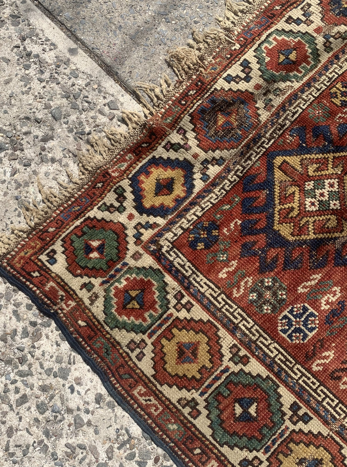 Handmade antique Caucasian Kazak rug in red color. The rug is from the end of 19th century in distressed condition.
