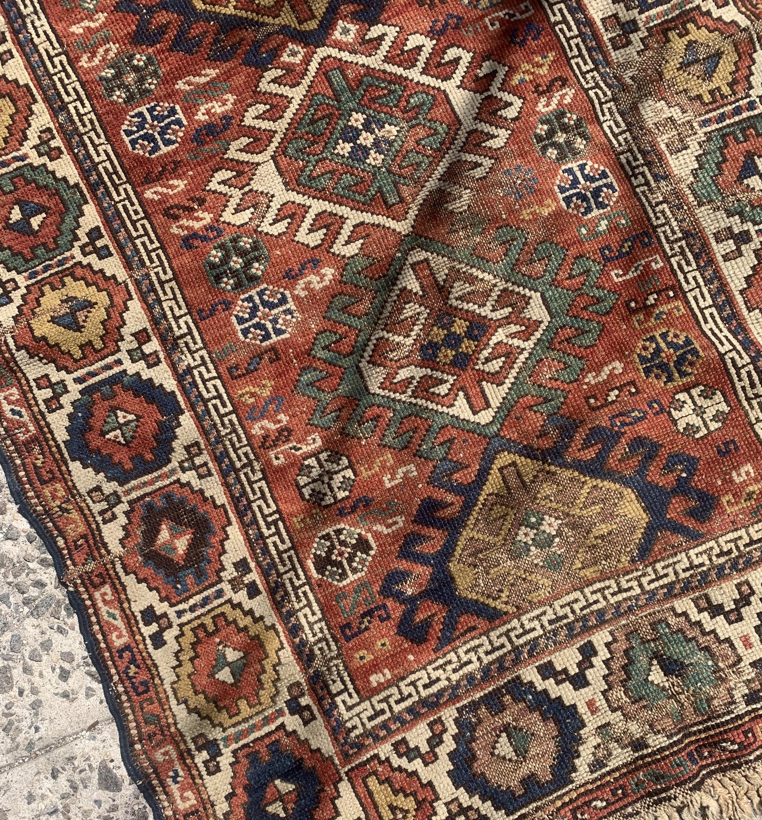 Handmade antique Caucasian Kazak rug in red color. The rug is from the end of 19th century in distressed condition.