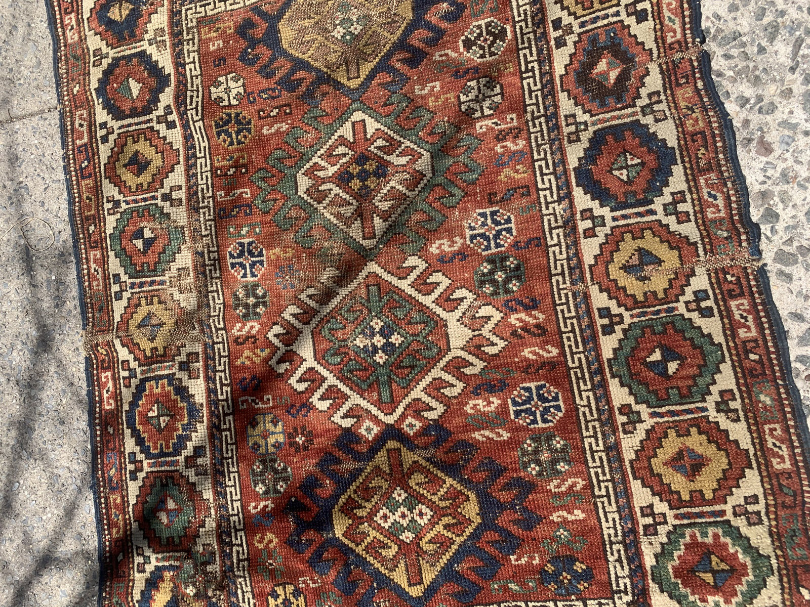 Handmade antique Caucasian Kazak rug in red color. The rug is from the end of 19th century in distressed condition.
