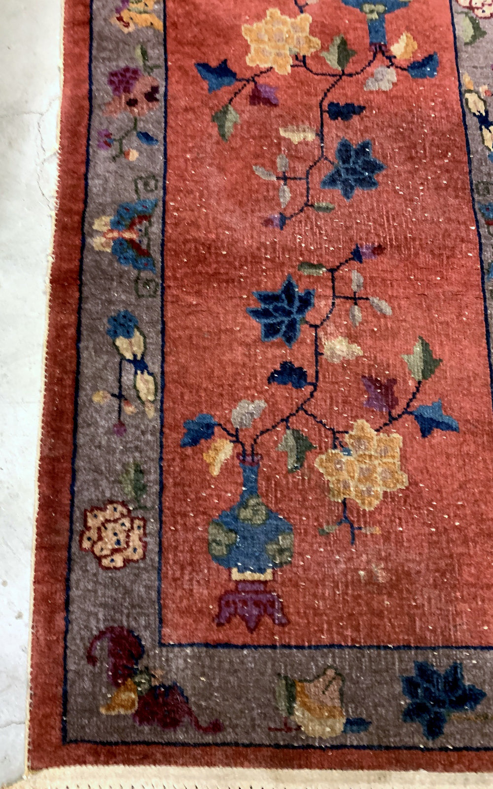 Handmade antique Art Deco Chinese rug in red shade with greyish border. The rug has traditional floral Art Deco design. It is from the beginning of 20th century in original condition, it has some low pile.