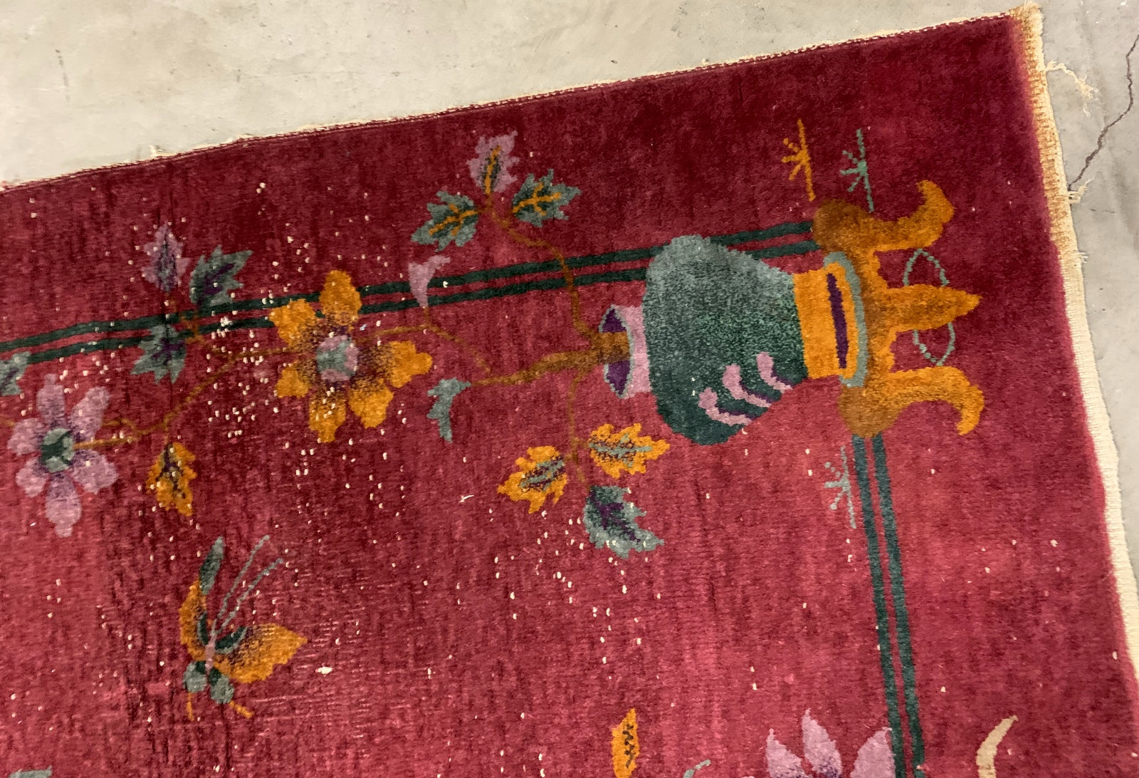 Handmade antique Art Deco Chinese rug in red color. The rug has traditional floral Art Deco design with some birds and vases. It is from the beginning of 20th century in original condition, it has some low pile.