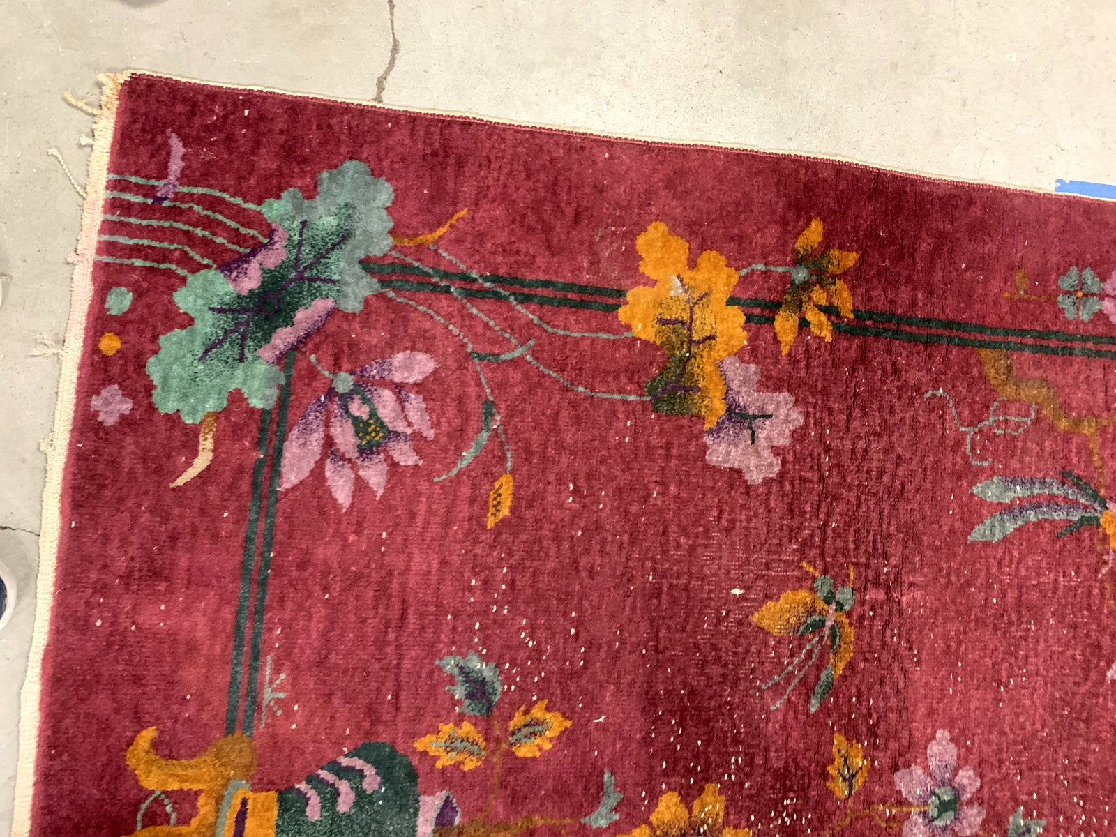 Handmade antique Art Deco Chinese rug in red color. The rug has traditional floral Art Deco design with some birds and vases. It is from the beginning of 20th century in original condition, it has some low pile.