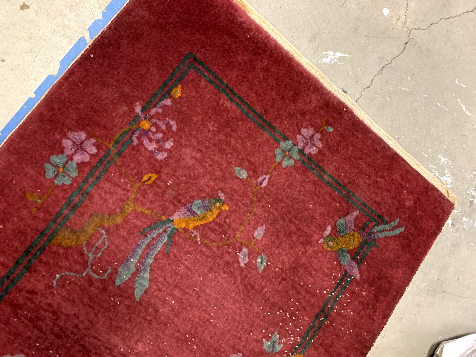 Handmade antique Art Deco Chinese rug in red color. The rug has traditional floral Art Deco design with some birds and vases. It is from the beginning of 20th century in original condition, it has some low pile.