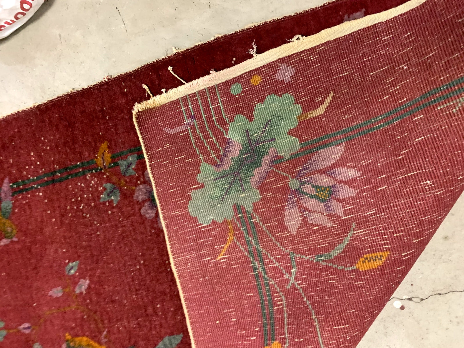 Handmade antique Art Deco Chinese rug in red color. The rug has traditional floral Art Deco design with some birds and vases. It is from the beginning of 20th century in original condition, it has some low pile.