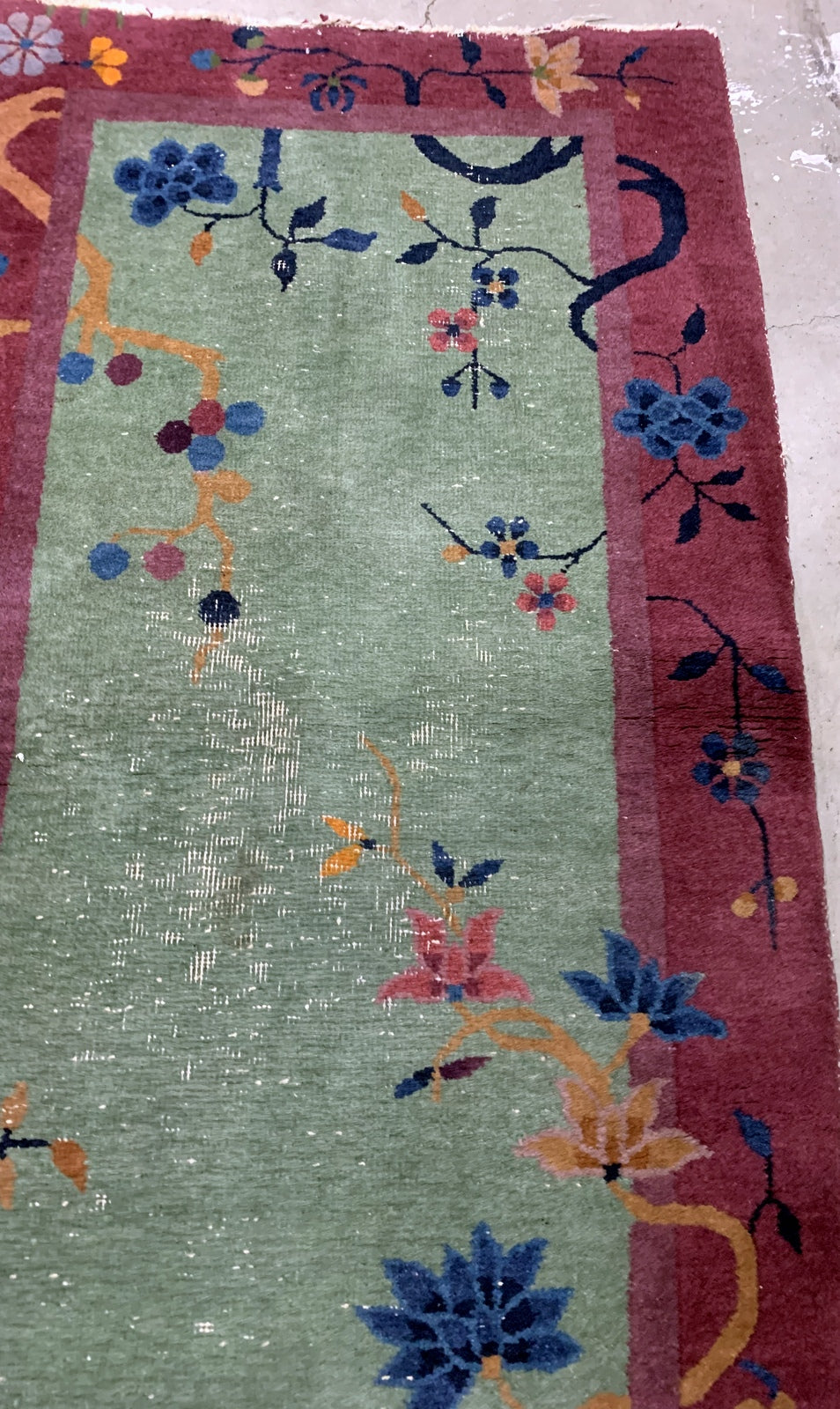 Handmade antique Art Deco Chinese rug in green color. The rug has traditional floral Art Deco design. It is from the beginning of 20th century in original condition, it has some low pile.