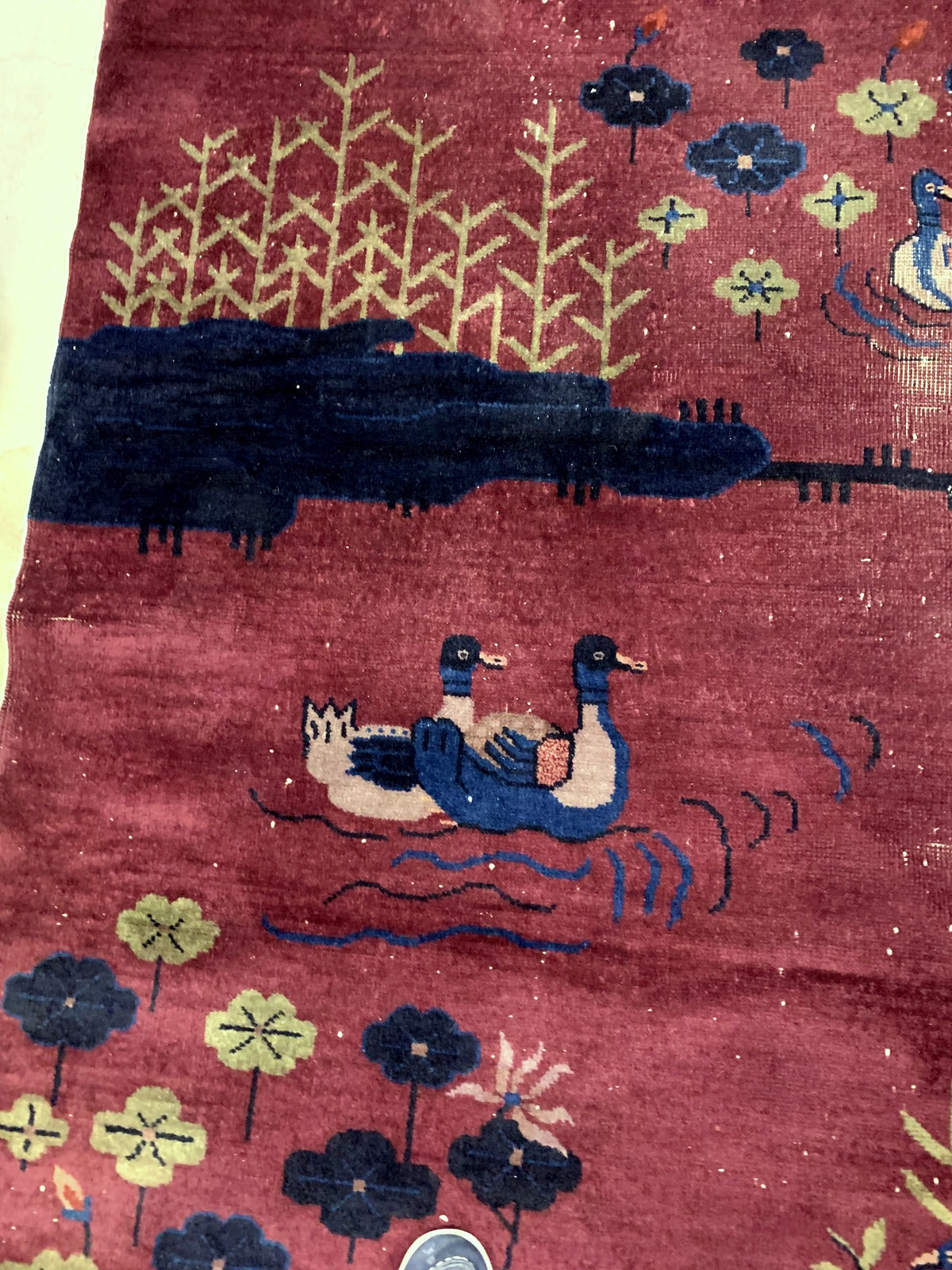 Handmade antique Art Deco Chinese rug in burgundy color with some ducks design. The rug is from the beginning of 20th century in original condition, it has some low pile.