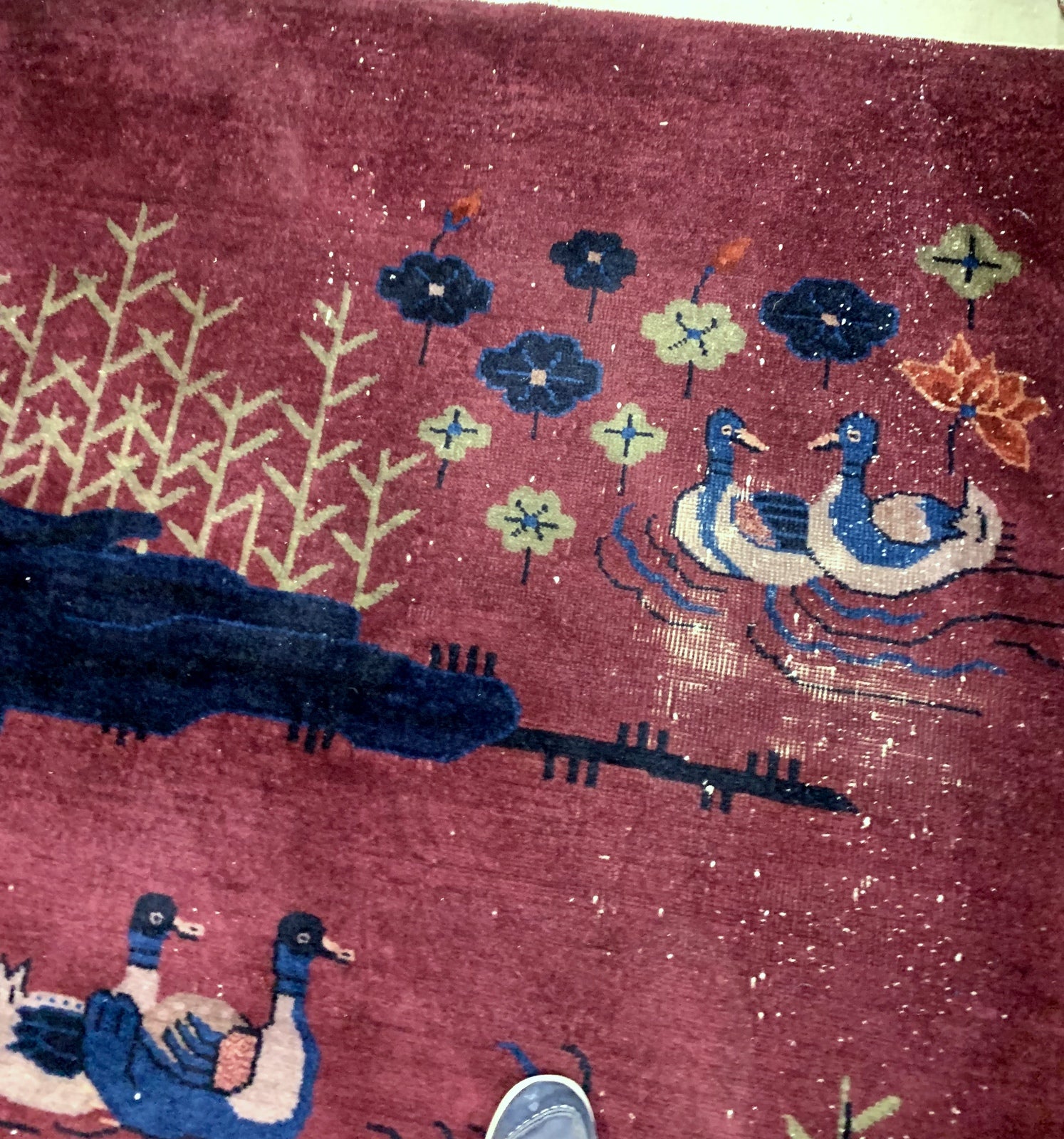 Handmade antique Art Deco Chinese rug in burgundy color with some ducks design. The rug is from the beginning of 20th century in original condition, it has some low pile.