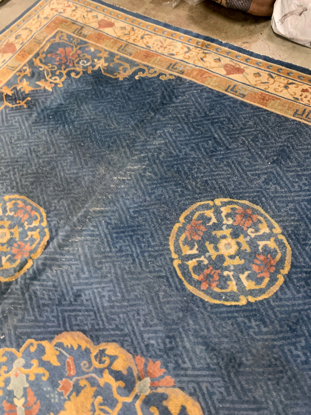 Handmade antique Peking Chinese rug in blue and beige colors. The rug is from the beginning of 20th century in original condition, it has some distressed areas.