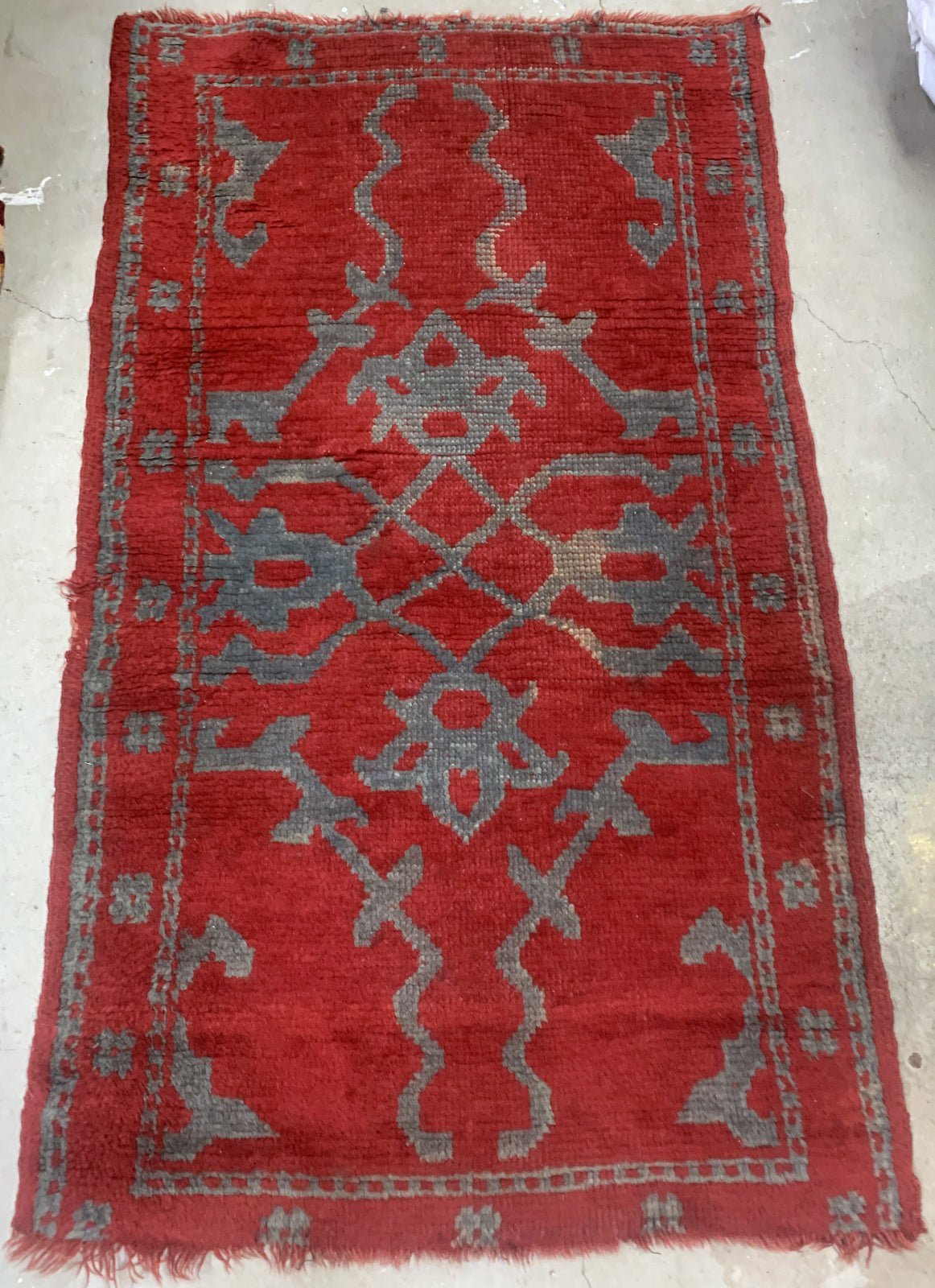 Handmade antique Turkish red rug from Oushak region. The rug is from the end of 19th century in original condition, it has some signs of age.
