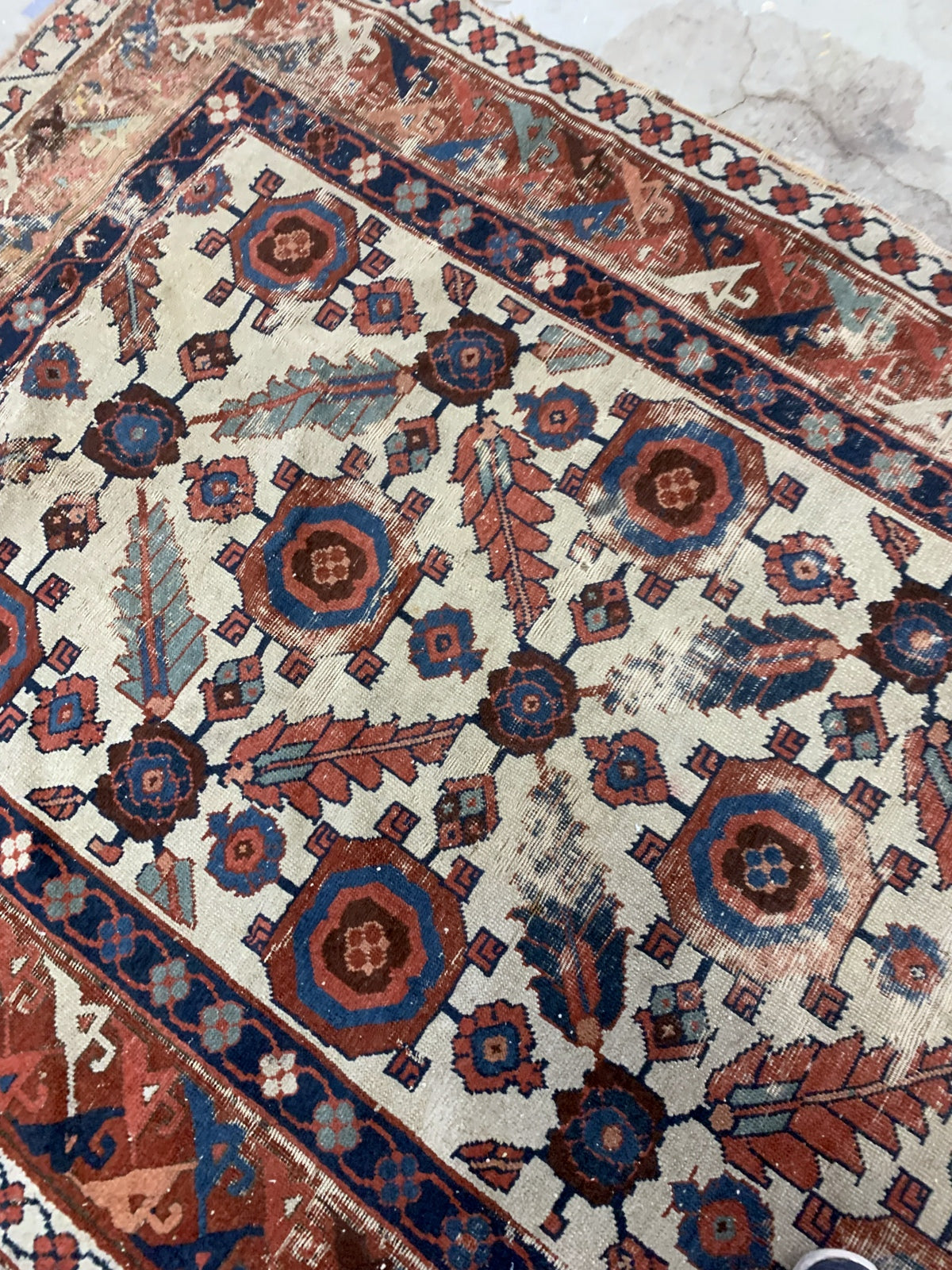 Very old handmade antique North-West Persian rug in white and red background colors. The rug is from the beginning of 19th century in distressed condition.  