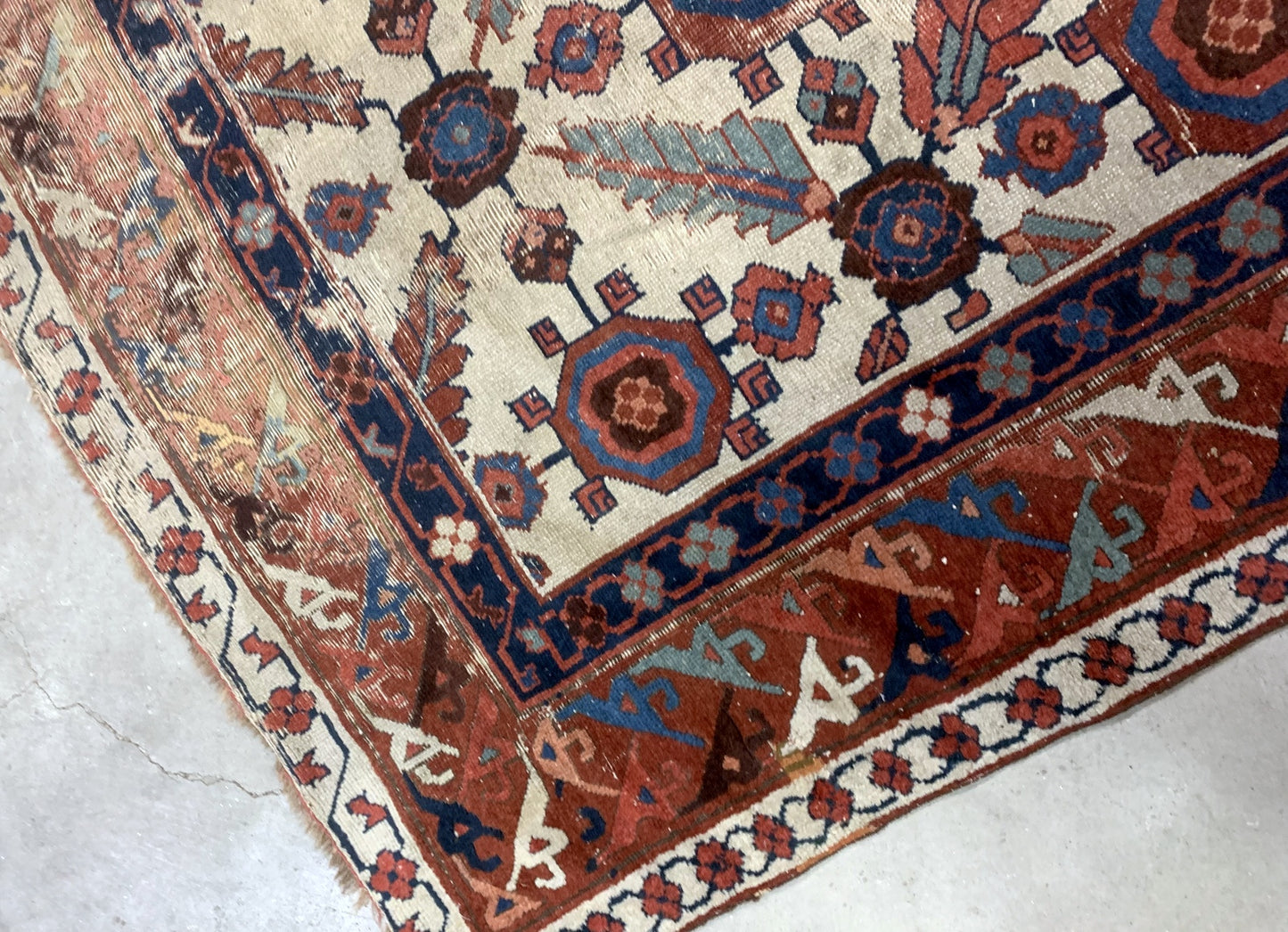 Very old handmade antique North-West Persian rug in white and red background colors. The rug is from the beginning of 19th century in distressed condition.  