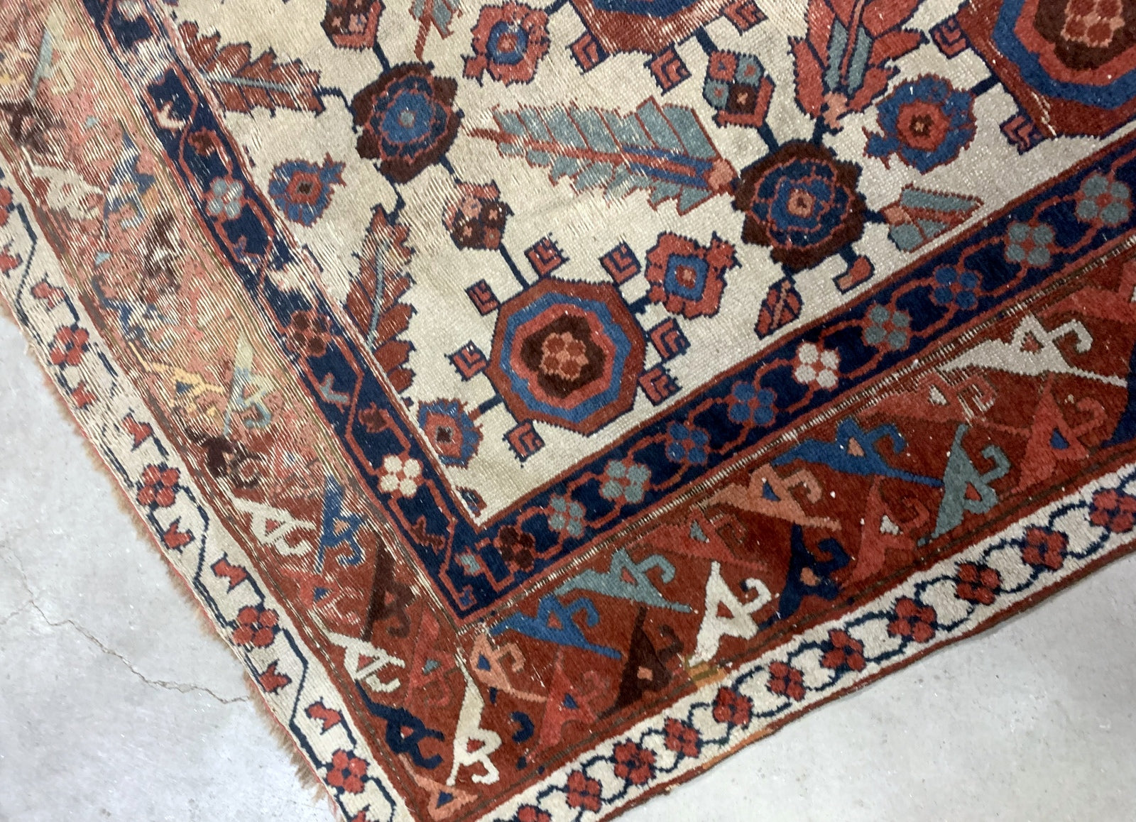Very old handmade antique North-West Persian rug in white and red background colors. The rug is from the beginning of 19th century in distressed condition.  