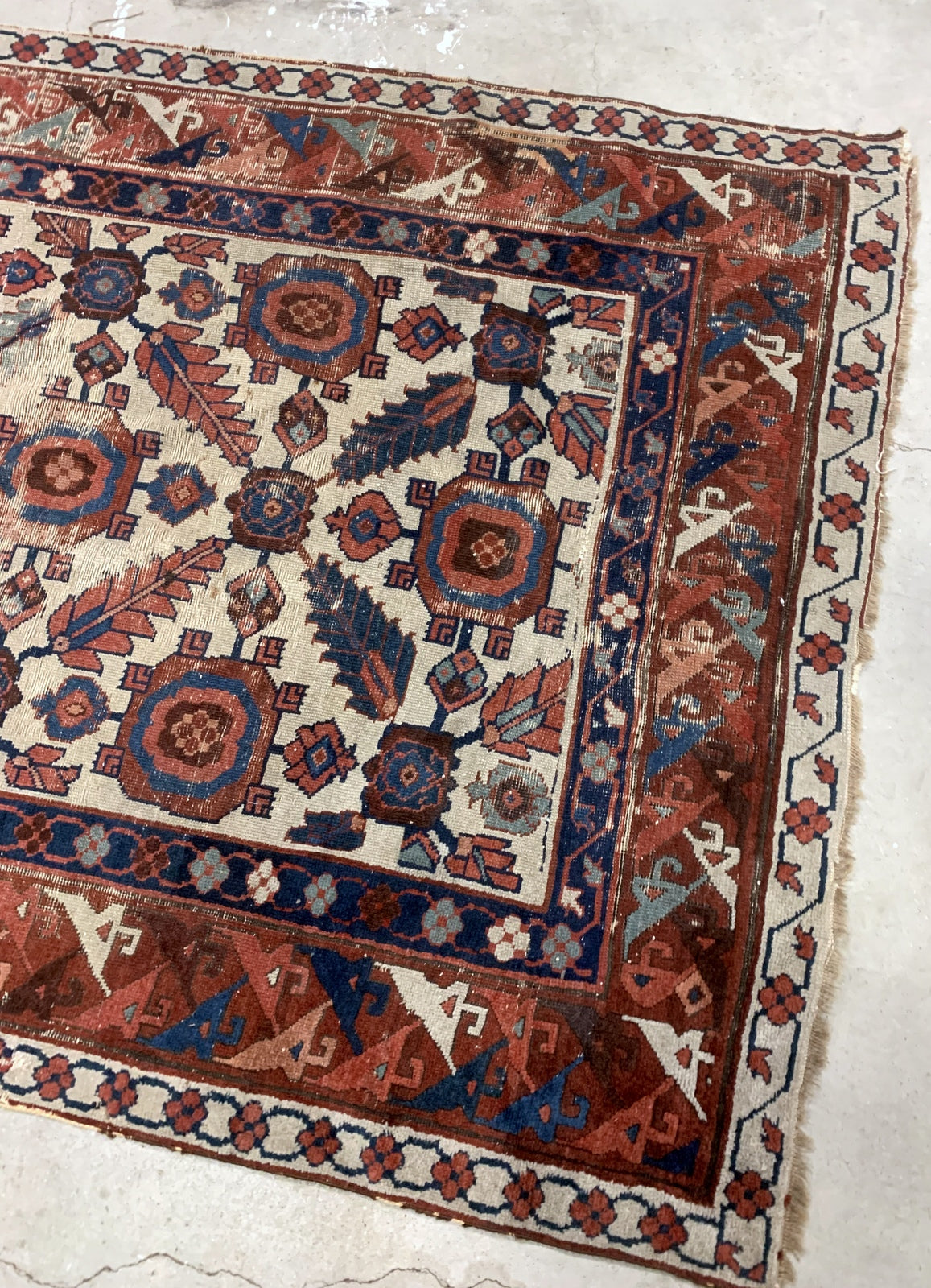 Very old handmade antique North-West Persian rug in white and red background colors. The rug is from the beginning of 19th century in distressed condition.  