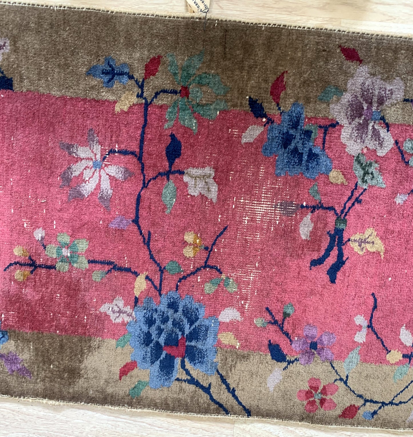 Close-up of historic rug showcasing the intricate Chinese weaving techniques and vibrant color palette.