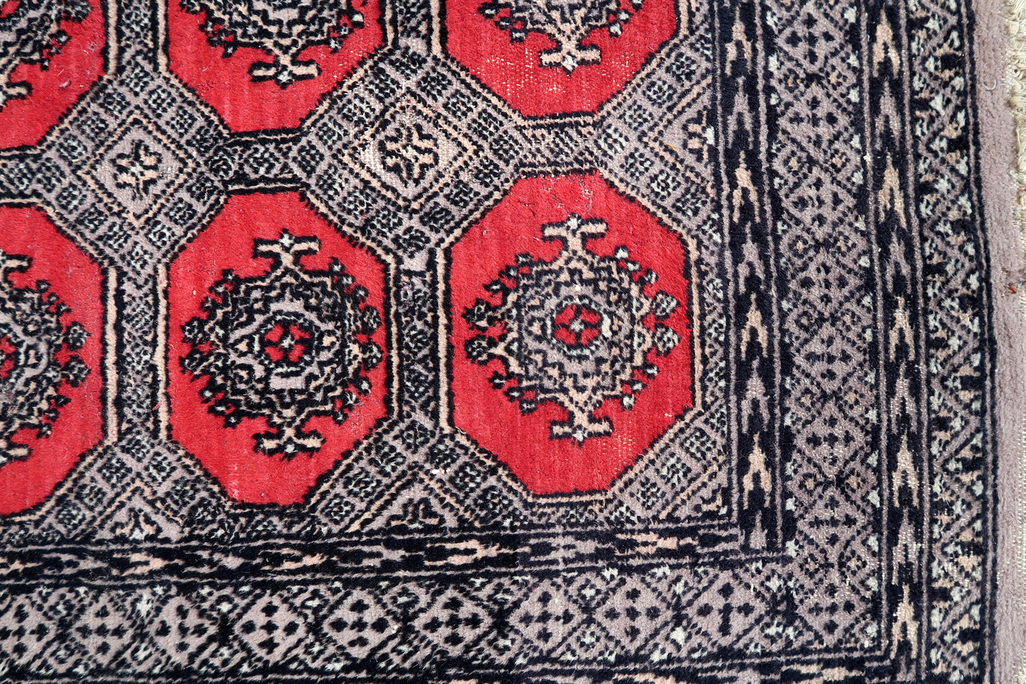 Handmade vintage Uzbek Bukhara rug in traditional design and red color. The rug is from the end of 20th century in original condition, it has some low pile.