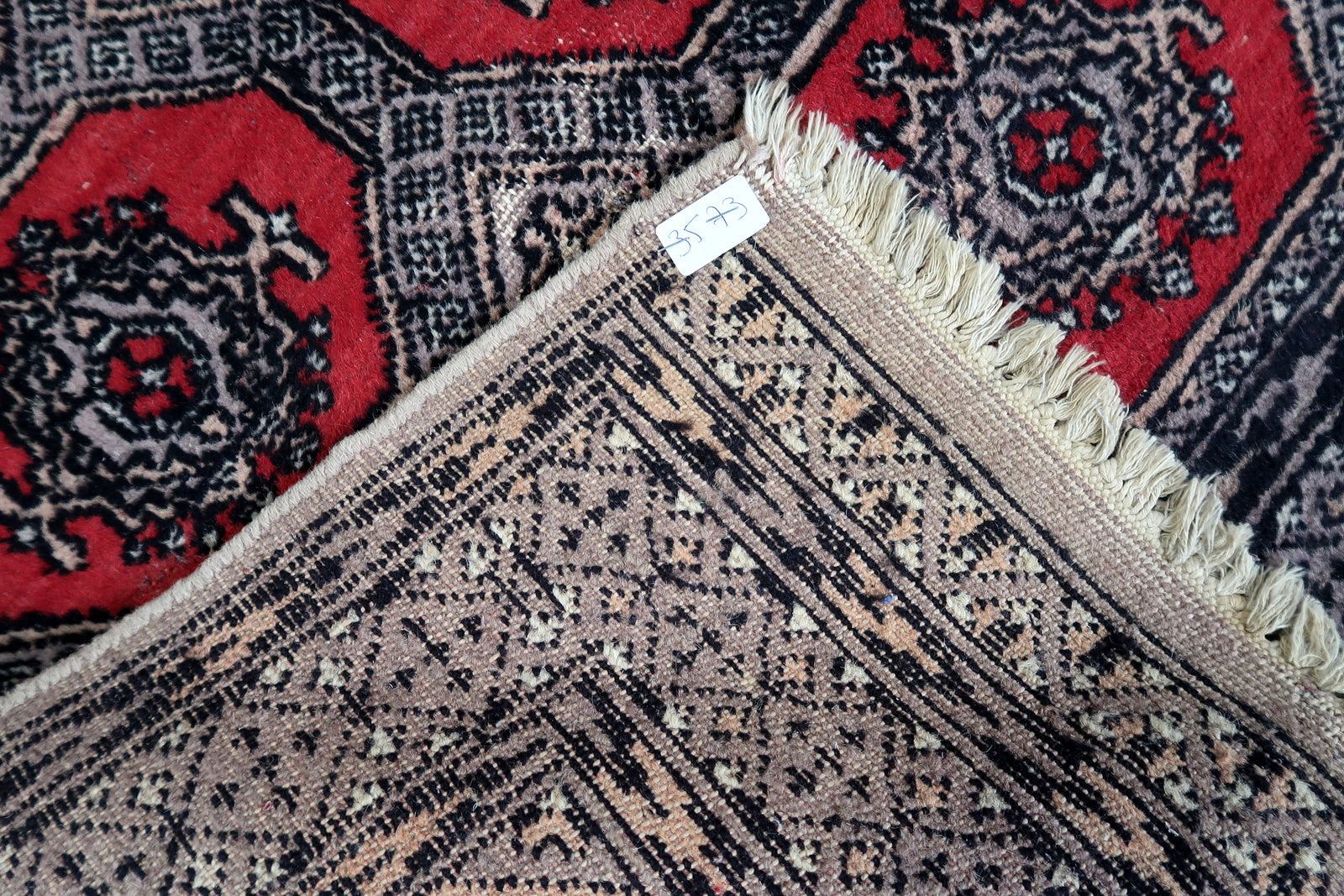 Handmade vintage Uzbek Bukhara rug in traditional design and red color. The rug is from the end of 20th century in original condition, it has some low pile.