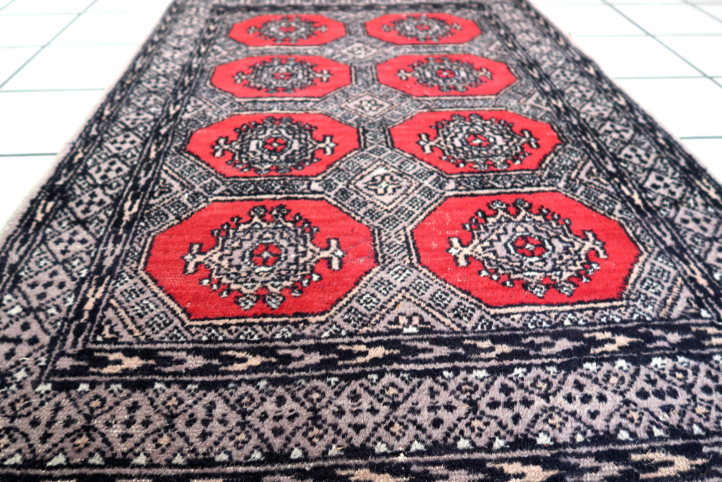 Handmade vintage Uzbek Bukhara rug in traditional design and red color. The rug is from the end of 20th century in original condition, it has some low pile.