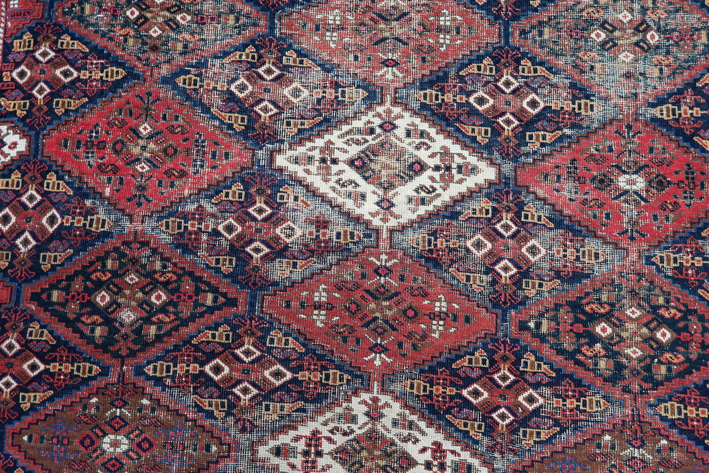 Handmade antique Persian rug from Afshar region. The rug is from the beginning of 20th century in distressed condition.