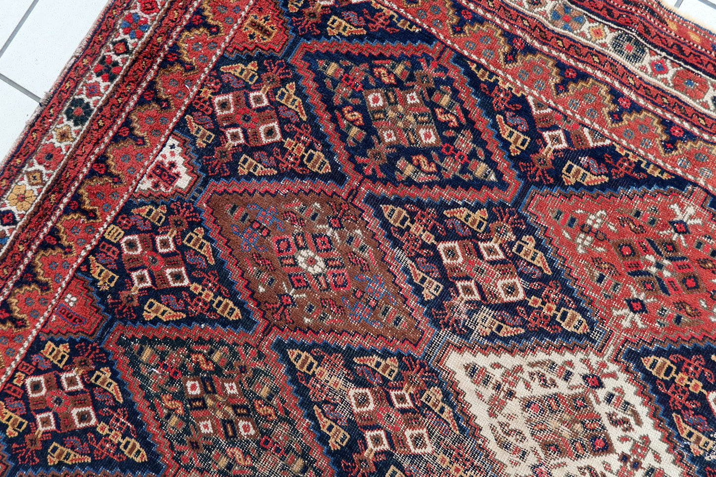 Handmade antique Persian rug from Afshar region. The rug is from the beginning of 20th century in distressed condition.