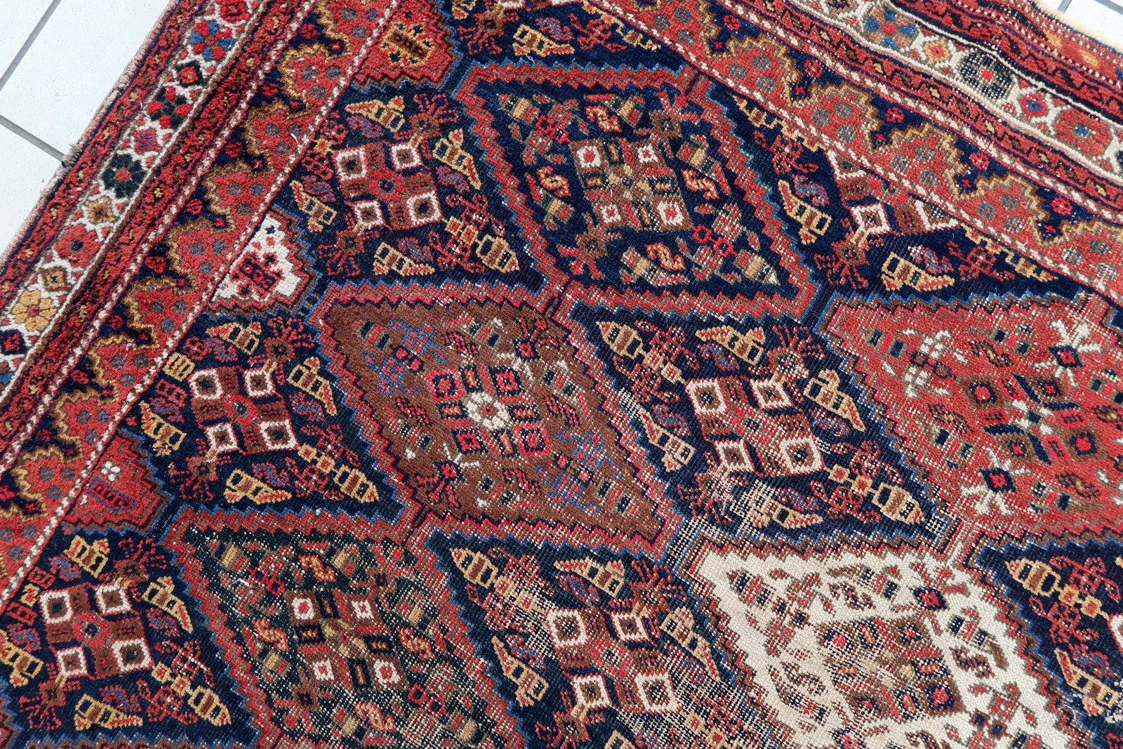 Handmade antique Persian rug from Afshar region. The rug is from the beginning of 20th century in distressed condition.