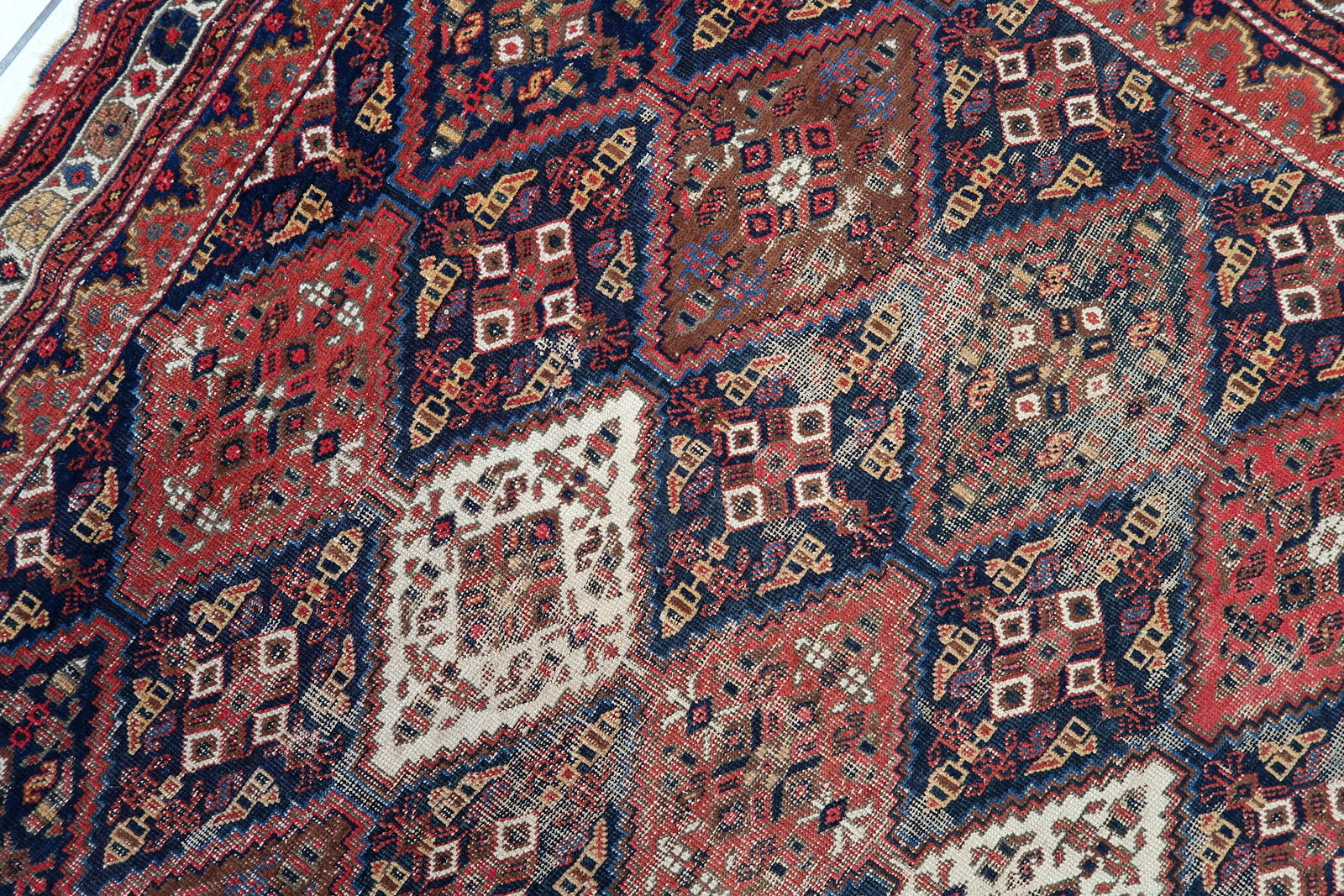 Handmade antique Persian rug from Afshar region. The rug is from the beginning of 20th century in distressed condition.