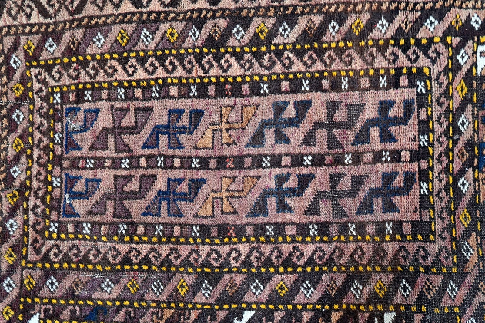 Handmade antique Afghan Baluch rug in tribal design. The rug is from the beginning of 20th century in original condition, it has some low pile.
