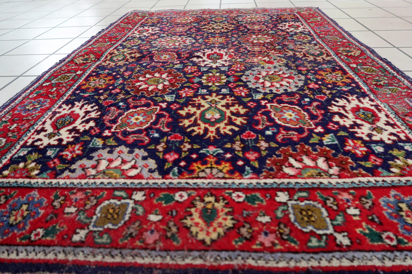 Handmade vintage Persian Tabriz rug in floral design and unusual purple background. The rug is from the middle of 20th century in good condition, it has some old restorations.