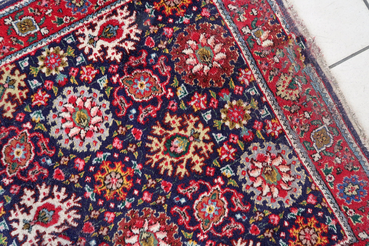 Handmade vintage Persian Tabriz rug in floral design and unusual purple background. The rug is from the middle of 20th century in good condition, it has some old restorations.