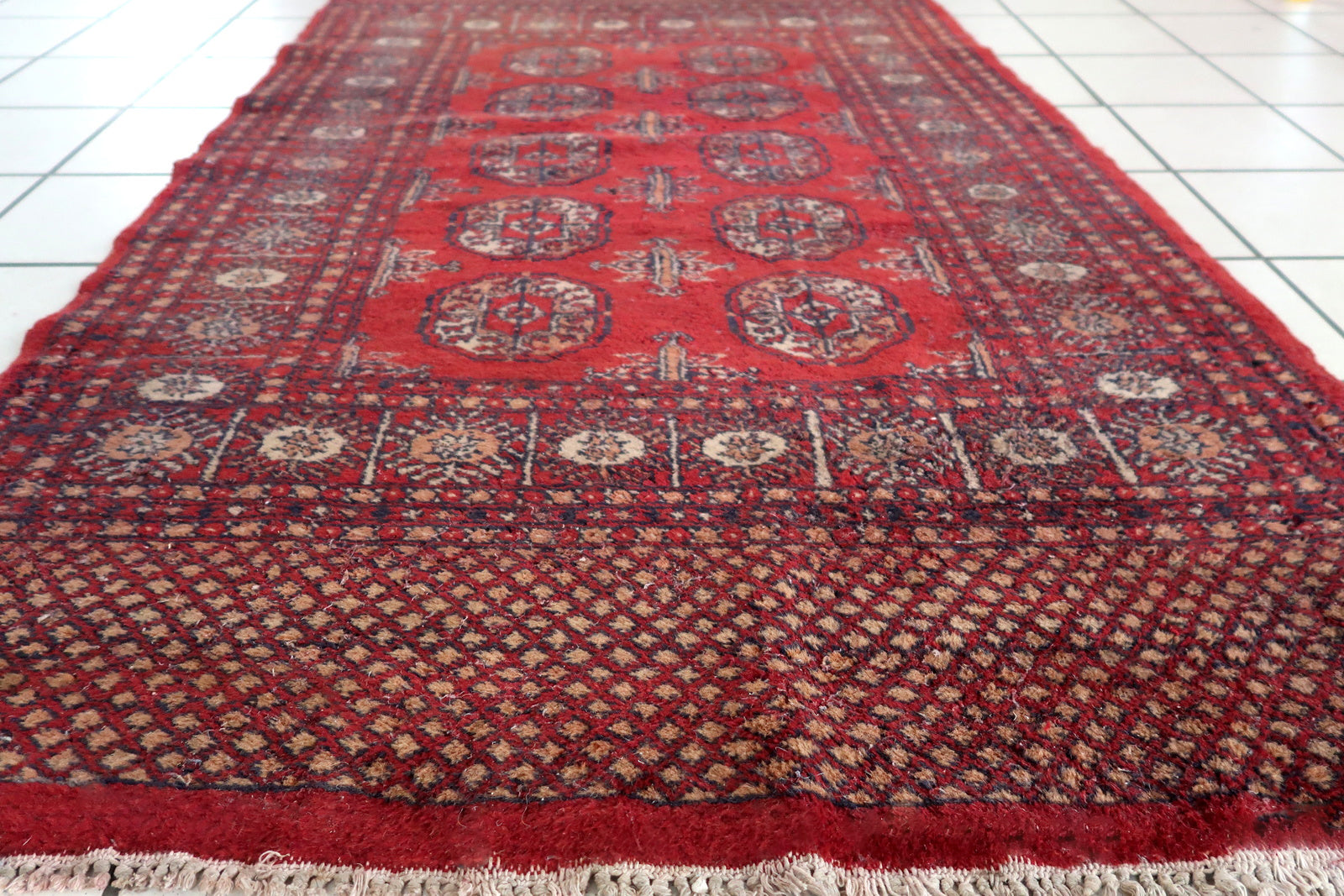 Handmade vintage Uzbek Bukhara rug in bright red color. The rug is from the end of 20th century in good condition, it has some signs of age and old restorations.