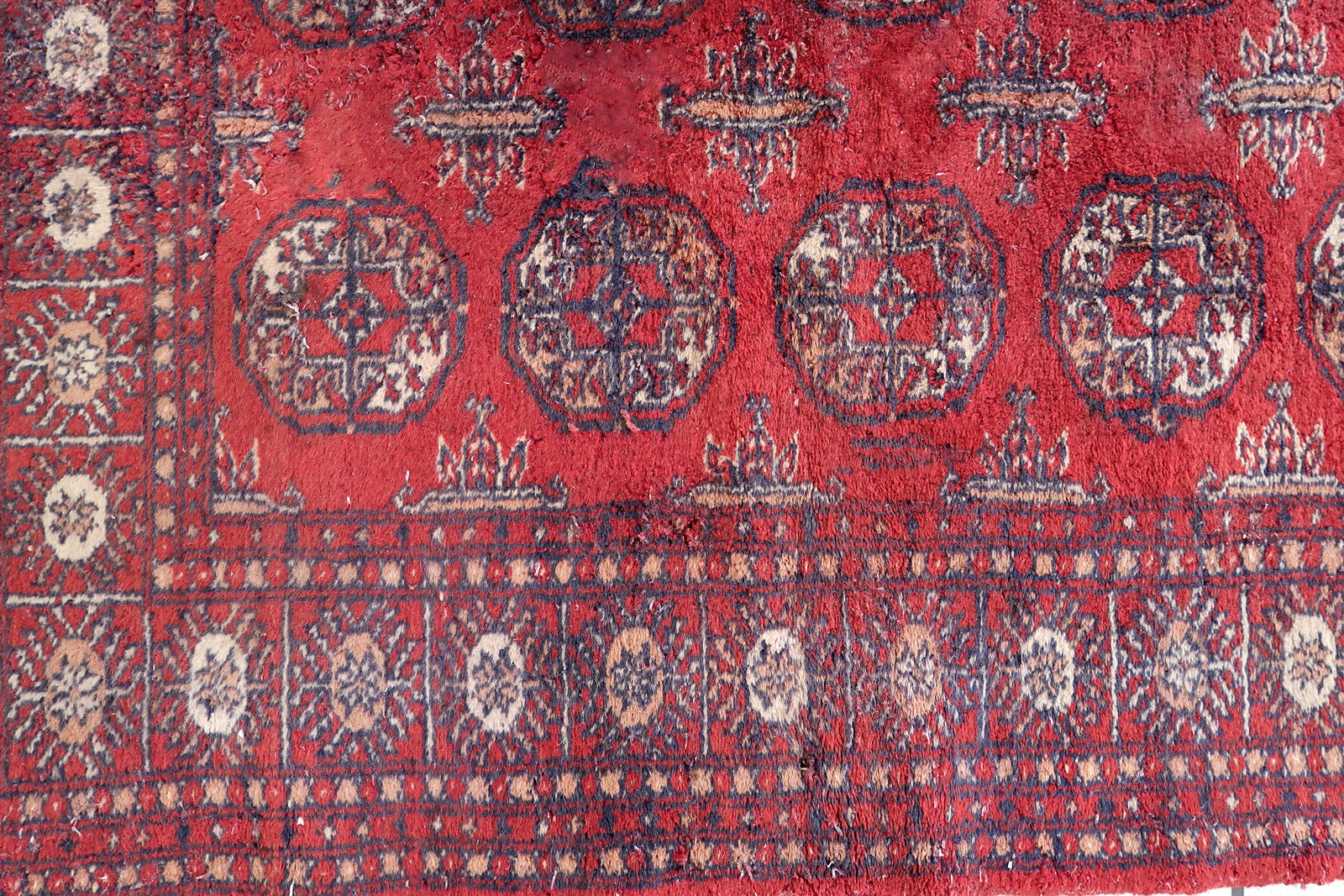 Handmade vintage Uzbek Bukhara rug in bright red color. The rug is from the end of 20th century in good condition, it has some signs of age and old restorations.